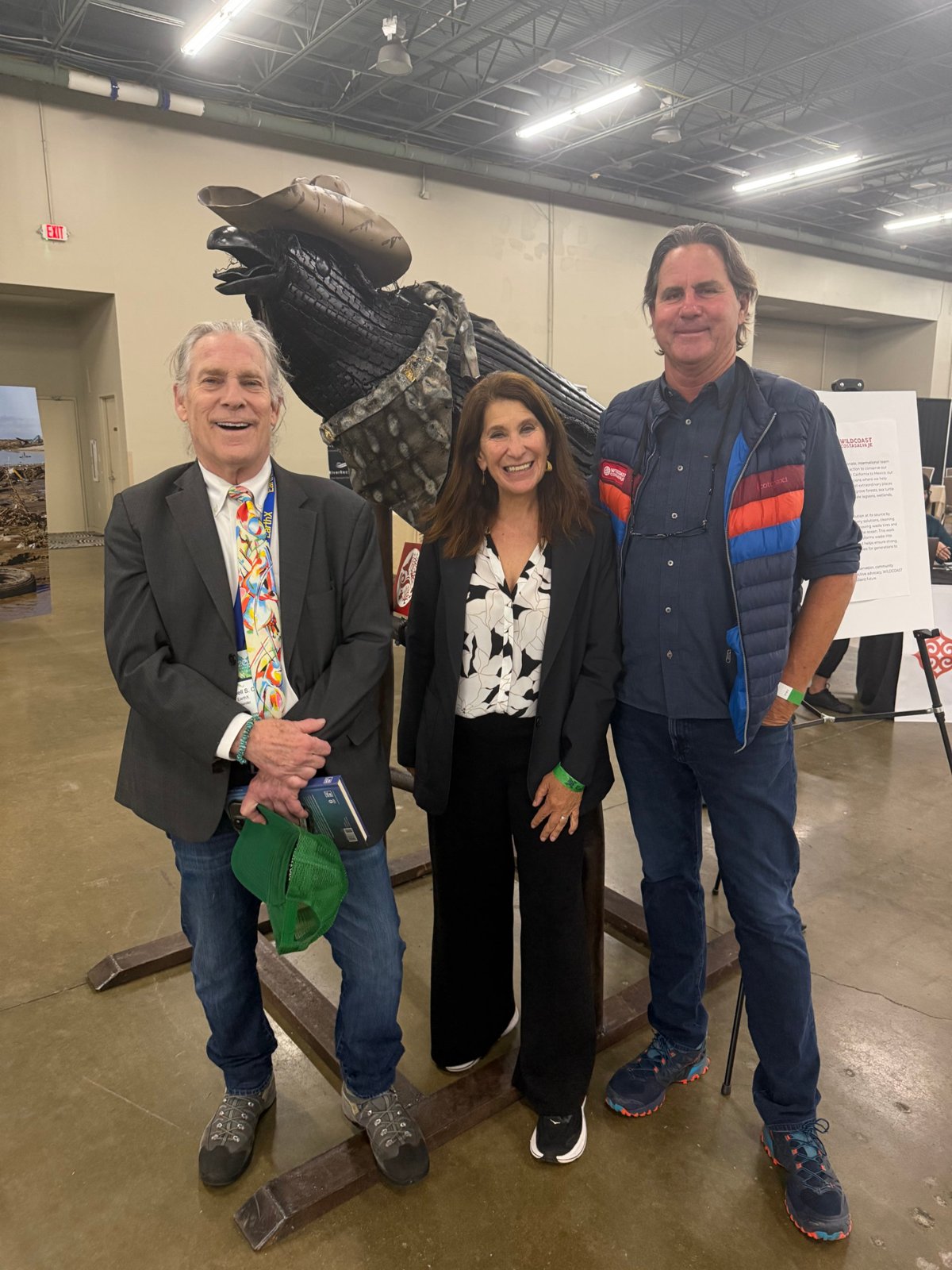 Trammell S. Crow, Fay Crevoshay and Serge Dedina standing in front of a sculpture made from tires pulled from the Tijuana River